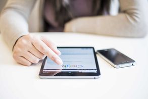 Woman using ipad mini. Screen displaying google search.