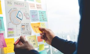 Person putting together marketing strategy on whiteboard